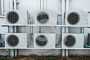 Group of air compressors outside the industry building wall.