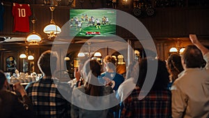 Group of American Football Fans Watching a Live Match Broadcast in a Sports Pub on TV. People