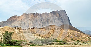 Group of ancient stone beehive tombs with Jebel Misht mountain in the background, archaeological site near al-Ayn, sultanate Oman