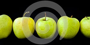 Group of apples including granny smith, golden delicious and royal gala on a black background