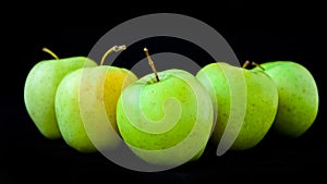 Group of apples including granny smith, golden delicious and royal gala on a black background