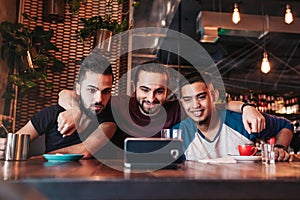 Group of arab friends taking selfie in lounge bar. Mixed race young men having fun