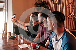 Group of arab friends taking selfie in lounge bar. Mixed race young men having fun. Best friends hangout together