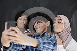 Group of arab teens taking selfie photo on smart phone