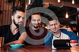 Group of arabian friends taking selfie in lounge bar. Mixed race young men having fun