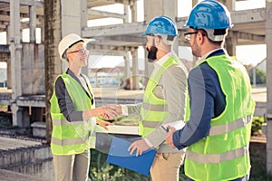 Group of architects or business partners shaking hands on a construction site