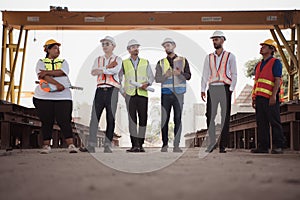 Group of architects, construction foremen, and construction engineers review the work and talk about how the project,
