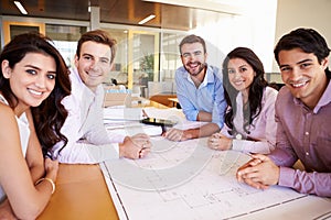 Group Of Architects Discussing Plans In Modern Office