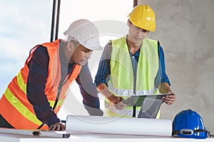 Group of architects look at blueprint and discussing project construction