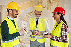 Group of architects talking on coffee break at construction site
