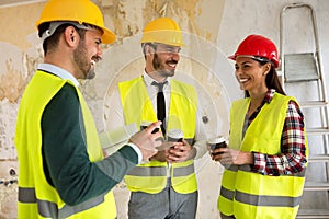 Group of architects talking on coffee break at construction site