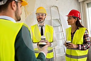 Group of architects talking on coffee break at construction site