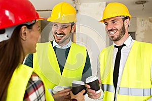 Group of architects talking on coffee break at construction site
