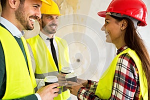 Group of architects talking on coffee break at construction site