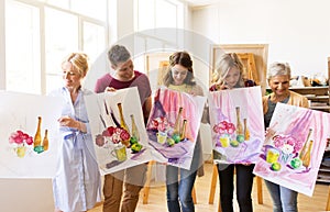 Group of artists with pictures at art school