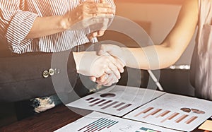 Group asia businessman woman  shakehand together create a mutually beneficial business relationship. Economic graph on the table