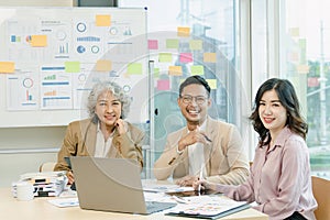 Group of Asia creative people in smart casual wear smiling in creative office workplace