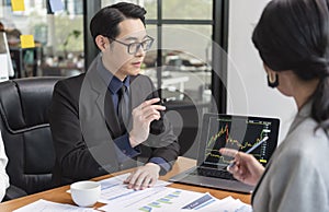 Group of Asian business people meeting about business plan and present and explain financial chart from laptop computer at office