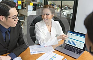 Group of Asian business people meeting about business plan and present and explain stock financial chart from laptop computer at