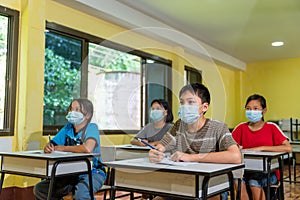 Group of asian children in classroom with face mask back at school after covid-19 quarantine and lockdown