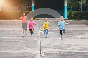 Group of asian children holding hands and running or walking tog