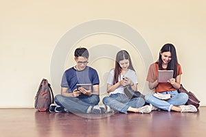 Group of Asian college student using tablet and mobile phone outside classroom. Happiness and Education learning concept. Back to