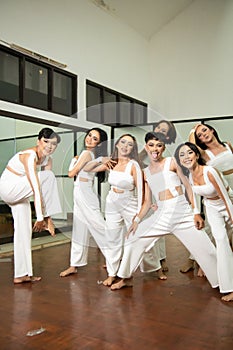 a group of Asian dancers joking around with their friends while rehearsing in a studio