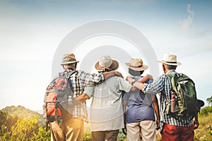 A group of Asian elders climbing and standing on the mountains