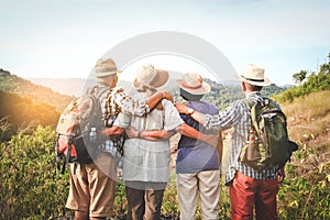 A group of Asian elders climbing and standing on the mountains