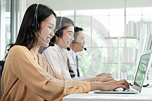 Group of Asian employee work in telemarketing customer service teams. Young operator woman working with headset smiling