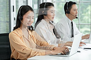 Group of Asian employee work in telemarketing customer service teams. Young operator woman working with headset smiling