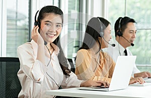 Group of Asian employee work in telemarketing customer service teams. Young operator woman working with headset smiling