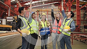 Group of Asian engineers and workers standing smiling wears safety helmet with joined stacking hand and hand up after working
