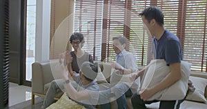 Group of asian flat mates watching sports competition on TV at home.