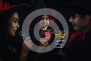 Group of asian friends in spooky costume having fun and drink cocktails at halloween celebration party in nightclub