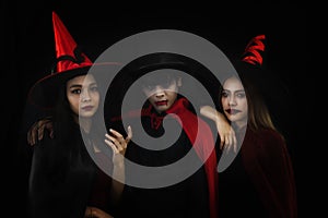 Group of asian friends in spooky costume of witch and vampire posing at halloween celebration party in nightclub