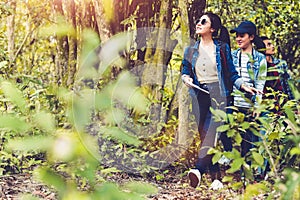 Group of Asian friendship adventure in forest jungle view background. Girl leading tourism team in nature. People lifestyle travel