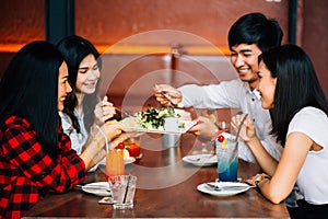 Group of Asian happy and smiling young man and women having a meal together with happiness