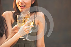 Group of asian happy young woman friends hand holding glass of wine,cheer and toast glass in celebration party dinner in pub or