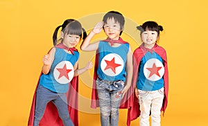 Group of Asian Kids Friendship playing superhero over colorful yellow isolated background.Superheroes and Fun Concept.Happy Time