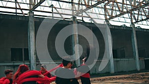 a group of Asian men are playing with red cloth ropes with their friends in a tug of war