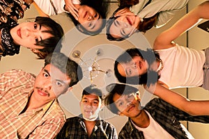 a group of Asian people are looking down simultaneously with serious faces