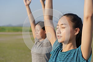 Group of Asian people practicing yoga In the prayer position and raised hands while standing outdoor in the summer,  Asia girl