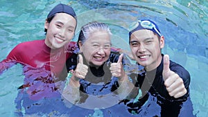 Group of Asian people of various ages smile happily exercise in water