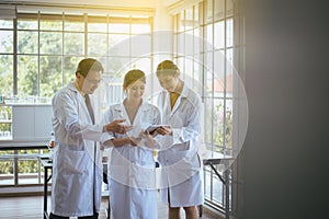 Group of asian scientist using tablet computer and analyzing data research information together in the laboratory