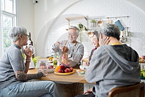 Group of Asian senior people friends making fruit juices for friends to drink in kitchen