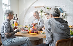 Group of Asian senior people friends making fruit juices for friends to drink in kitchen.colorful fruits and vegetables.