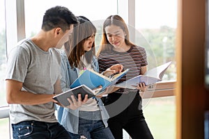 Group of asian students researching data for homework assignment in library