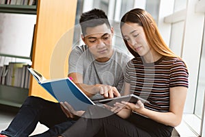 Group of asian students researching data for homework assignment in library