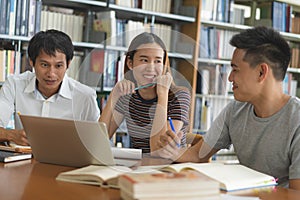 Group of asian students researching for project in library of university